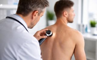 medecin-examine-peau-patient-cabinet